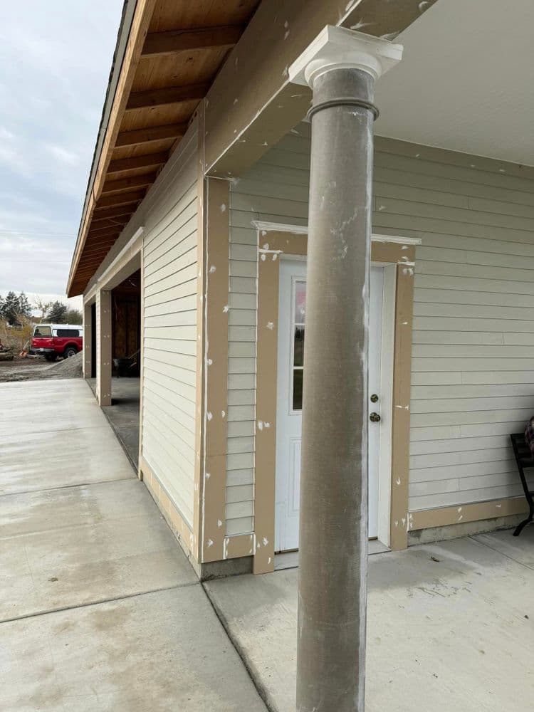 Exterior view of a newly constructed home with a concrete porch and decorative column.